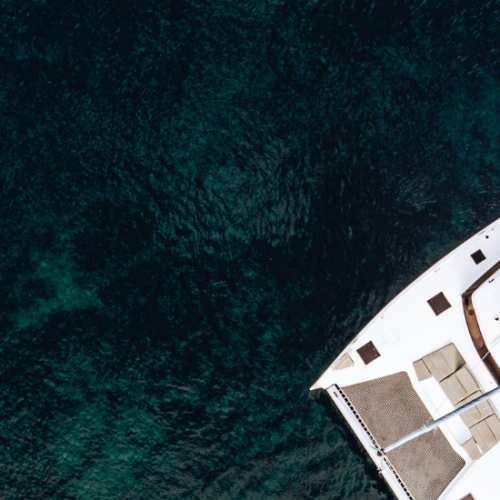 A drone view of a catamaran yacht anchored in a bay