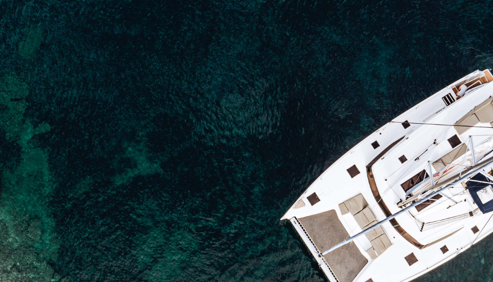 A drone view of a catamaran yacht anchored in a bay