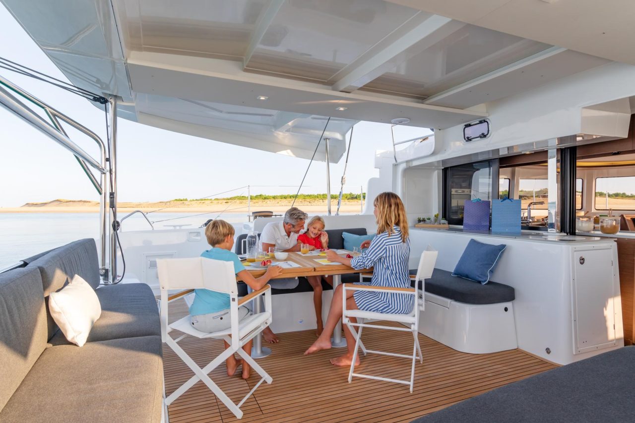 Family enjoying the spacious cockpit of the Lagoon 46 sailing catamaran