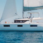 Lagoon 46 Iconic sailing with a man at the helm and women enjoying the foredeck