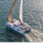 Lagoon 46 sailing with a man on the flybridge and a child on the foredeck