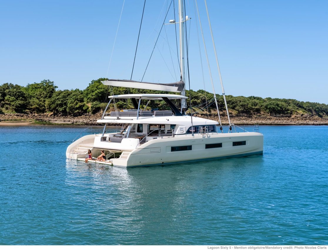 Lagoon Sixty 5 sailing catamaran at anchor with women enjoying the swimming deck