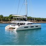Lagoon Sixty 5 sailing catamaran at anchor with women enjoying the swimming deck