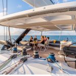 Guests having lunch on the amazing flybridge of the Lagoon Sixty 5 with a beautiful view
