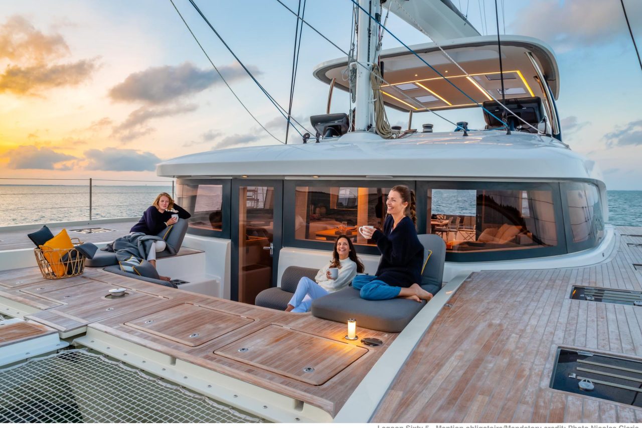 Women enjoying sunset on the comfortable foredeck of the Lagoon Sixty 5 sailing catamaran