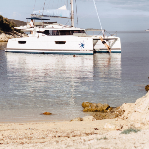 Man diving from an anchored yacht in a Mediterranean bay