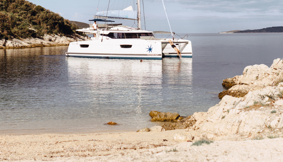 Man diving from an anchored yacht in a Mediterranean bay