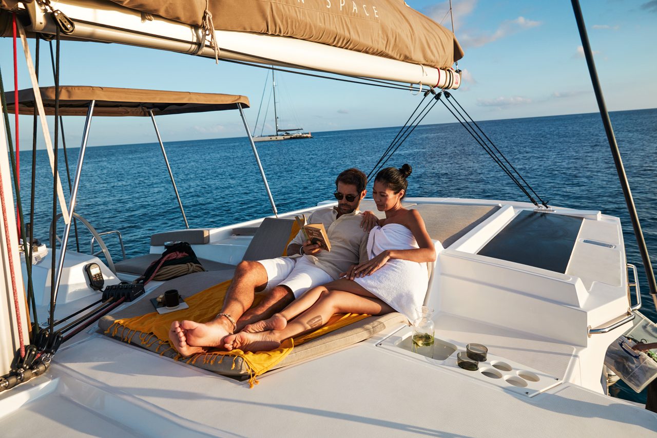 Couple reading a book on the cozy flybridge of the Bali 4.2 sailing catamaran