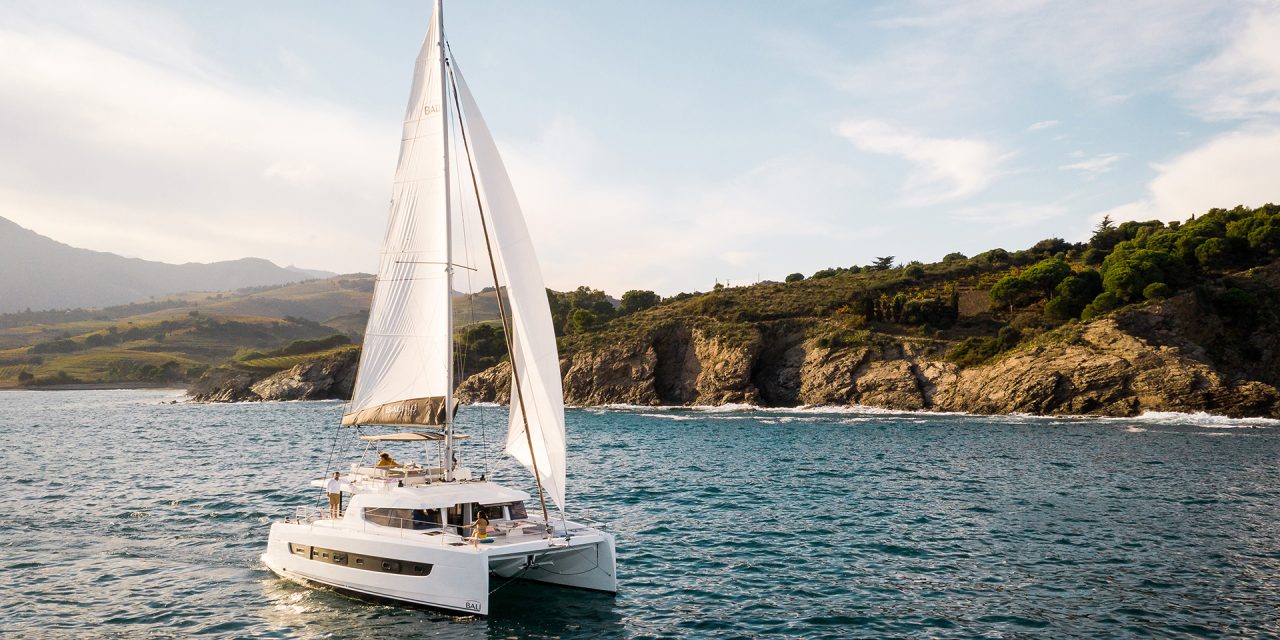 Bali 4.6 sailing with a woman at the helm and guests enjoying the foredeck