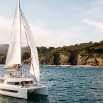 Bali 4.6 sailing with a woman at the helm and guests enjoying the foredeck