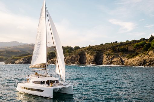 Bali 4.6 sailing with a woman at the helm and guests enjoying the foredeck