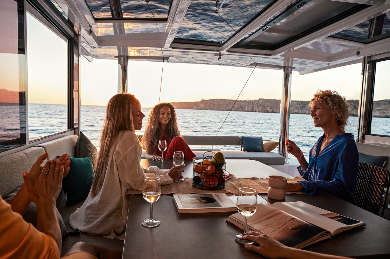 Guests having a drink in the cockpit of the Bali 4.8 at sunset