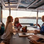 Guests having a drink in the cockpit of the Bali 4.8 at sunset