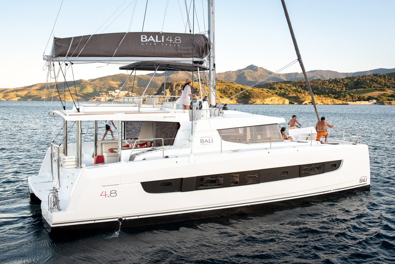 Bali 4.8 sailing with a woman at the helm and guests enjoying the foredeck