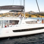 Bali 4.8 sailing with a woman at the helm and guests enjoying the foredeck