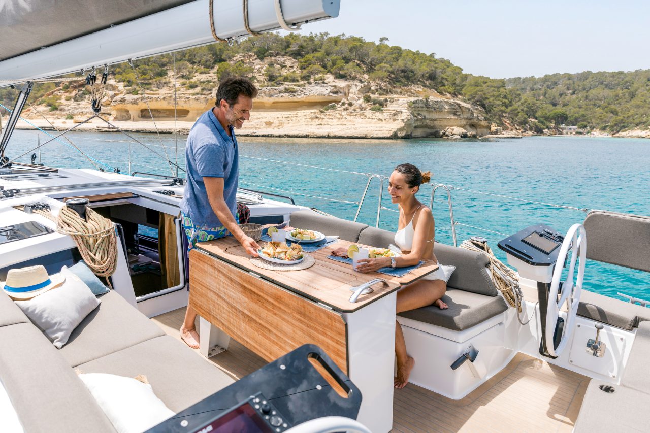 Couple having a lunch in the comfortable cockpit of the Dufour 41 sailing monohull
