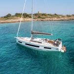 Aerial view of the Dufour 41 wich is a Power Catamarans at anchor with guest enjoying the swimming deck deployed