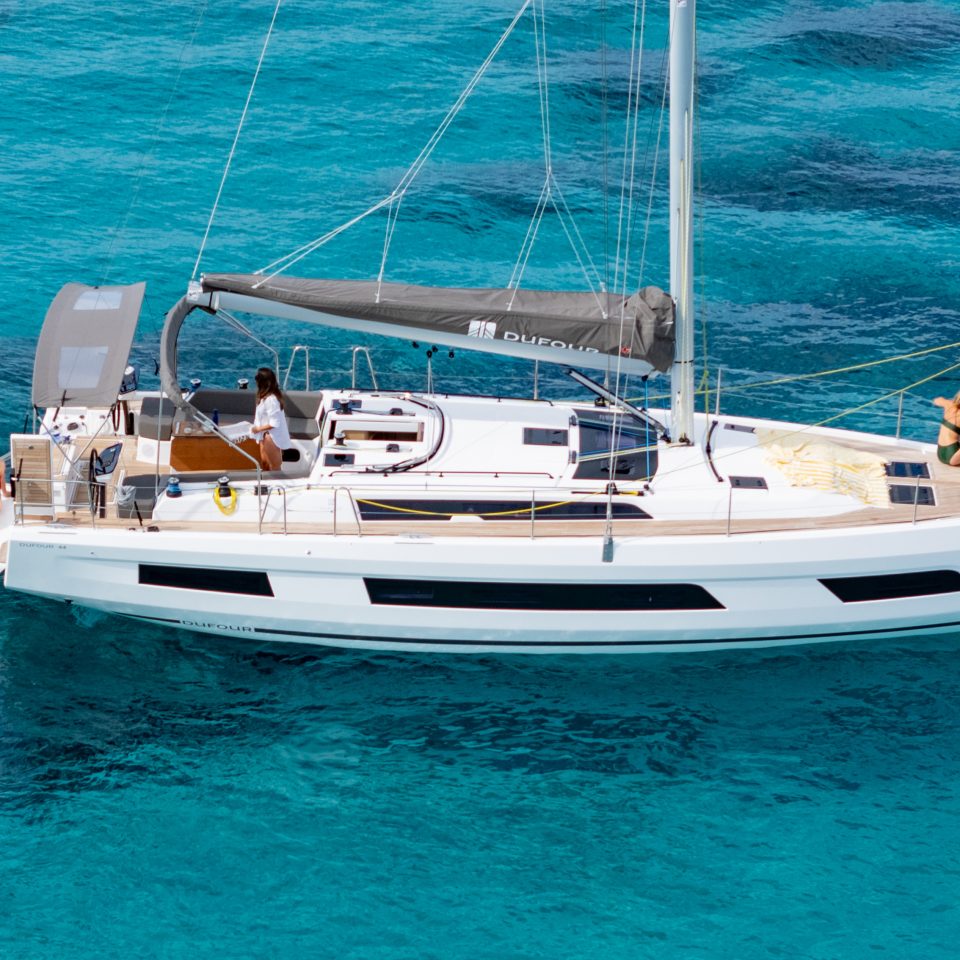 Dufour 44 at anchor with women enjoying the several decks