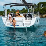 Dufour 44 at anchor with women enjoying the several decks