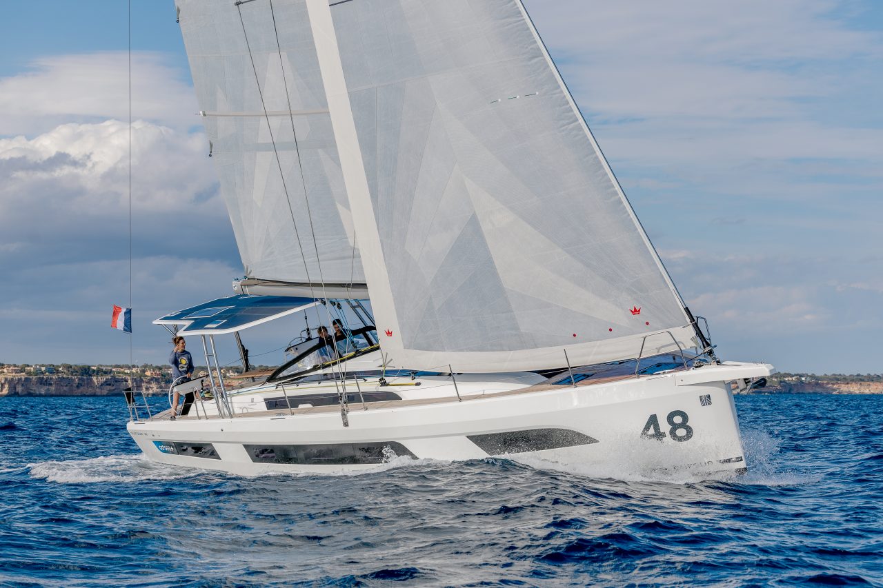 Dufour 48 sailing with a woman at the helm and guests in the cockpit