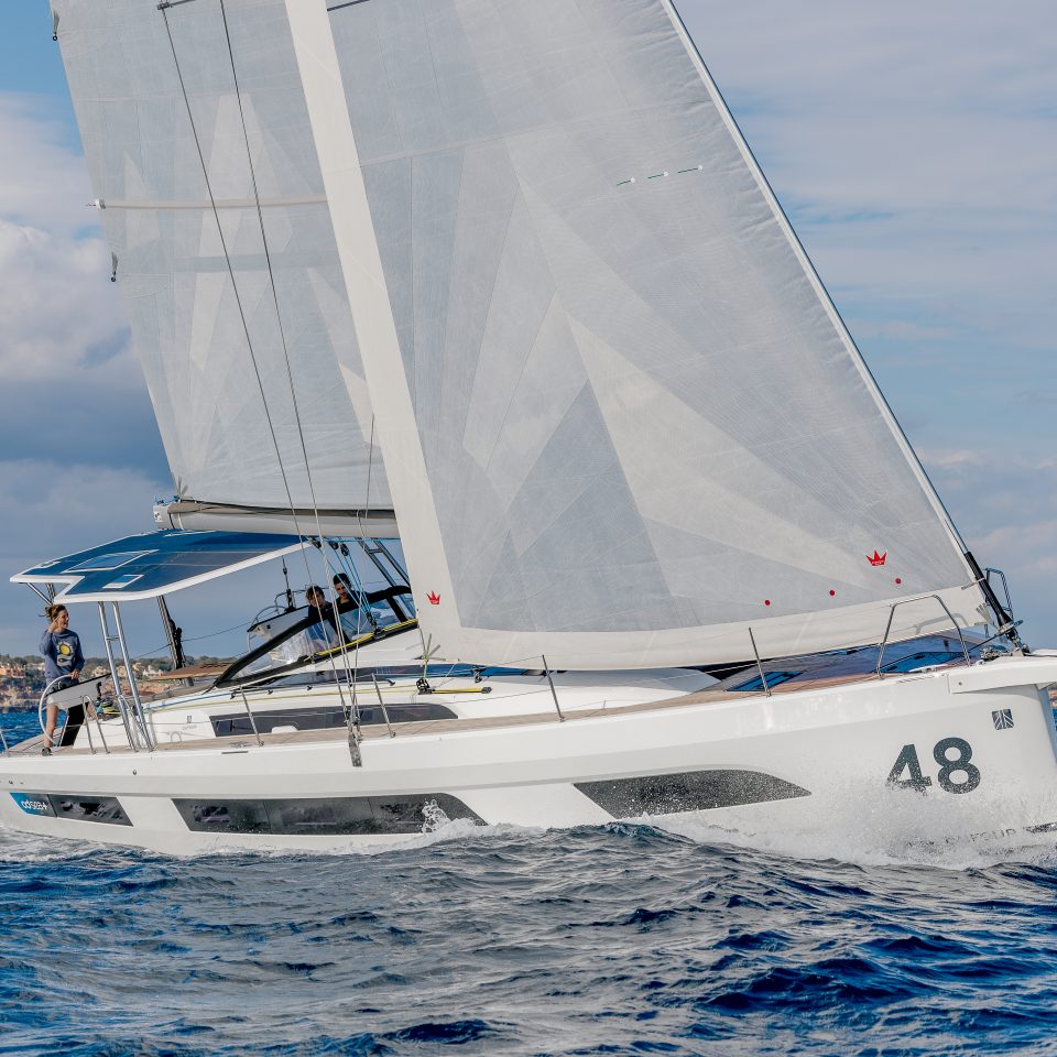 Dufour 48 sailing with a woman at the helm and guests in the cockpit