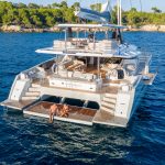 Fountaine Pajot Thira 80 navegando con una pareja en la cubierta de proa