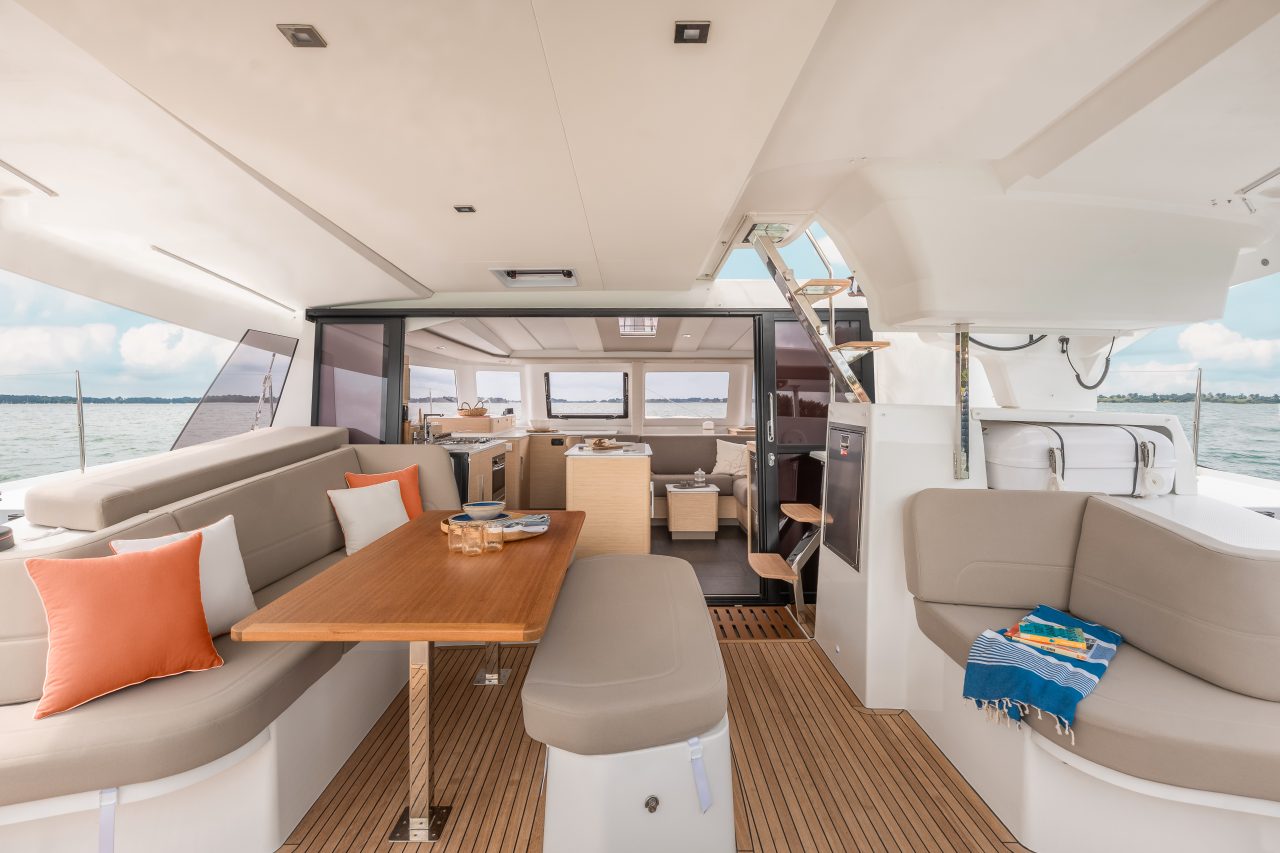 Familie beim Mittagessen im komfortablen Cockpit des Fountaine Pajot NEW 41 Segelkatamarans