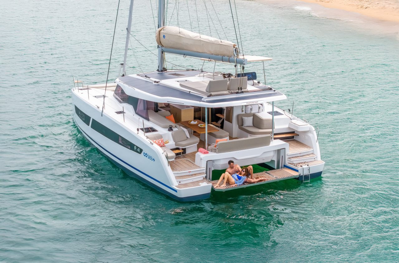A couple enjoying the swimdeck of the Fountaine Pajot NEW 41 sailing catamaran at anchor