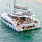 A couple enjoying the swimdeck of the Fountaine Pajot NEW 41 sailing catamaran at anchor
