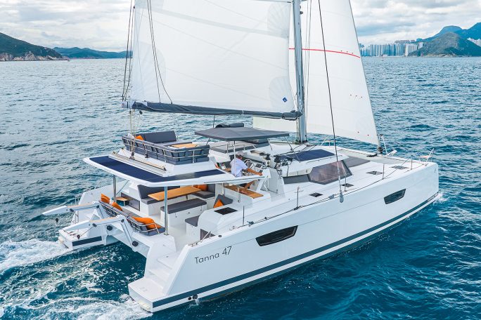 Fountaine Pajot Tanna 47 sailing near the coast with a man at the helm