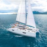 Fountaine Pajot Tanna 47 sailing near the coast with a man at the helm