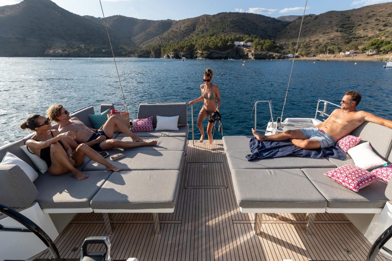 Guests enjoying cockpit benches and swimming deck on the Jeanneau 55 sailing monohull