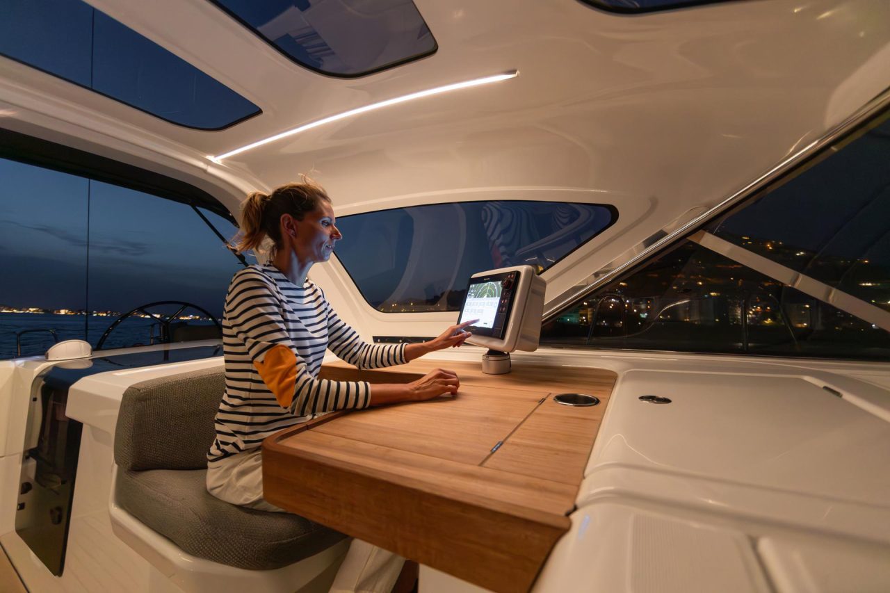 A woman in the helm station of the Jeanneau 55 sailing monohull