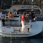 Rear view of the Jeanneau 55 at anchor with guests having a barbecue in the cockpit