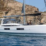 Jeanneau Yacht 60 at anchor with guests enjoying swimming deck and foredeck