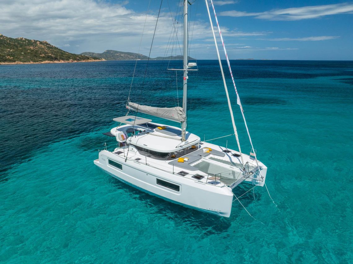 Lagoon 38 at anchor in turquoise sea near the coast