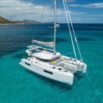 Lagoon 38 at anchor in turquoise sea near the coast