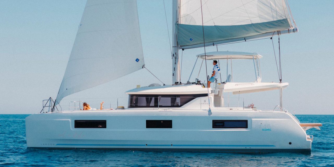 Lagoon 46 Iconic sailing with a man at the helm and women enjoying the foredeck
