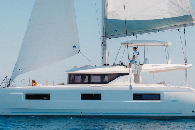 Lagoon 46 Iconic sailing with a man at the helm and women enjoying the foredeck