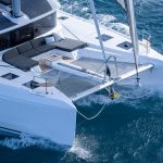 Lagoon 46 Iconic sailing with a man at the helm and children enjoying the foredeck