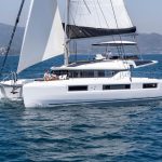 Lagoon 51 sailing with a man at the helm and guests enjoying the foredeck