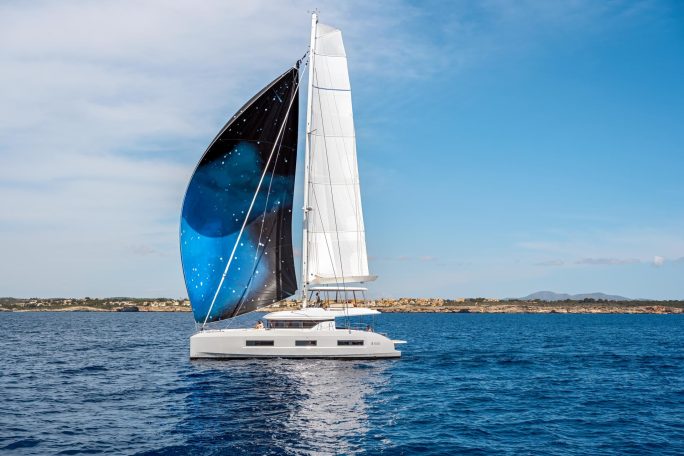 Lagoon 55 sailing with a man at the helm and women enjoying the flybridge and the cockpit