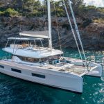 Lagoon 55 sailing catamaran at anchor with guests enjoying the flybridge