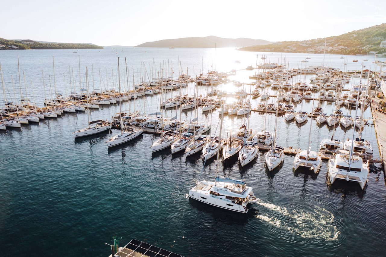 Vista aérea de un puerto deportivo en el Mediterráneo con un barco saliendo