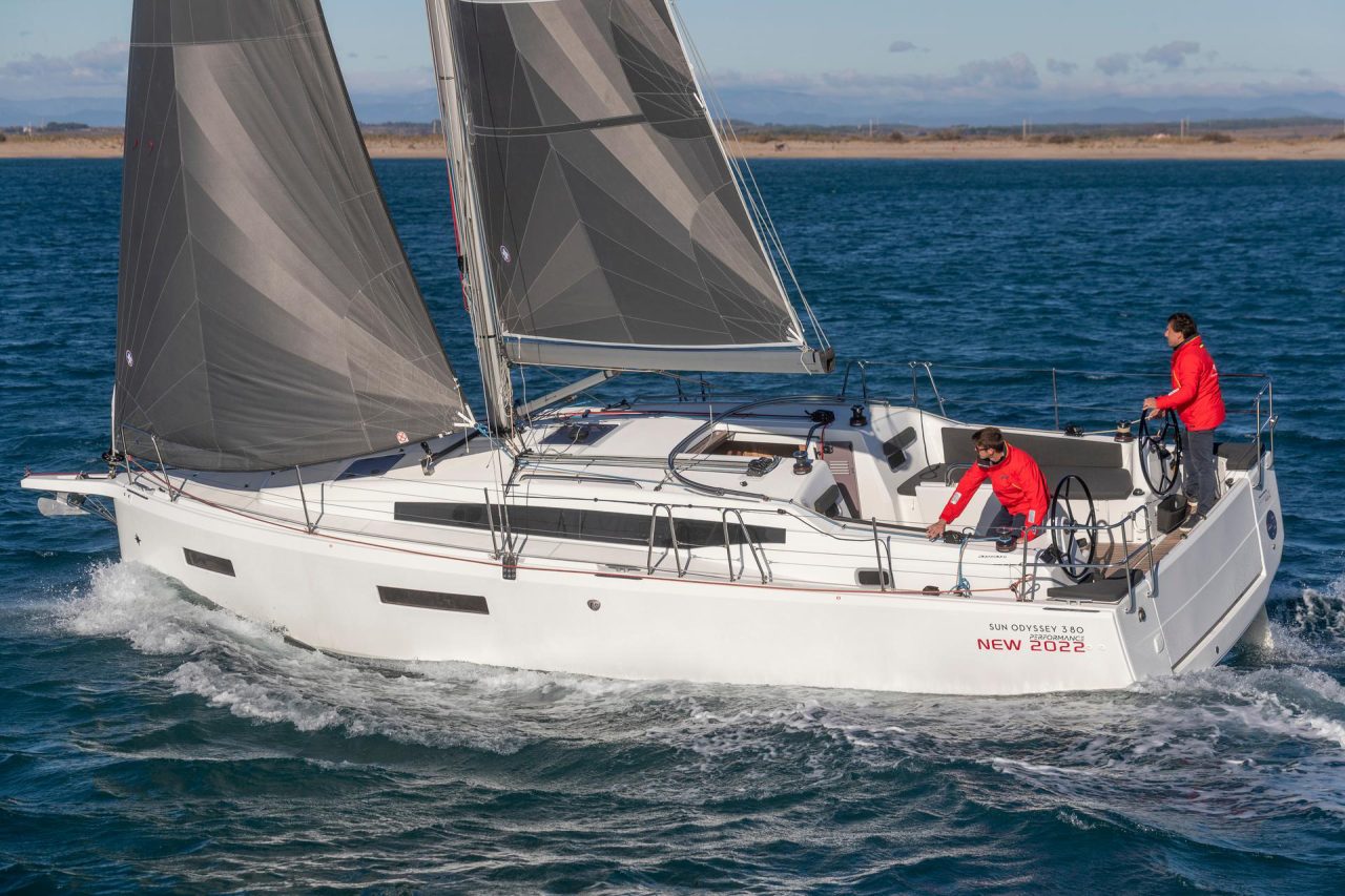 Side view of the Sun Odyssey 380 sailing with a man at the helm and a man managing the line organizer