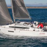 Side view of the Sun Odyssey 380 sailing with a man at the helm and a man managing the line organizer