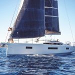 Jeanneau Sun Odyssey 410 sailing with a man at the helm and a woman enjoying the foredeck