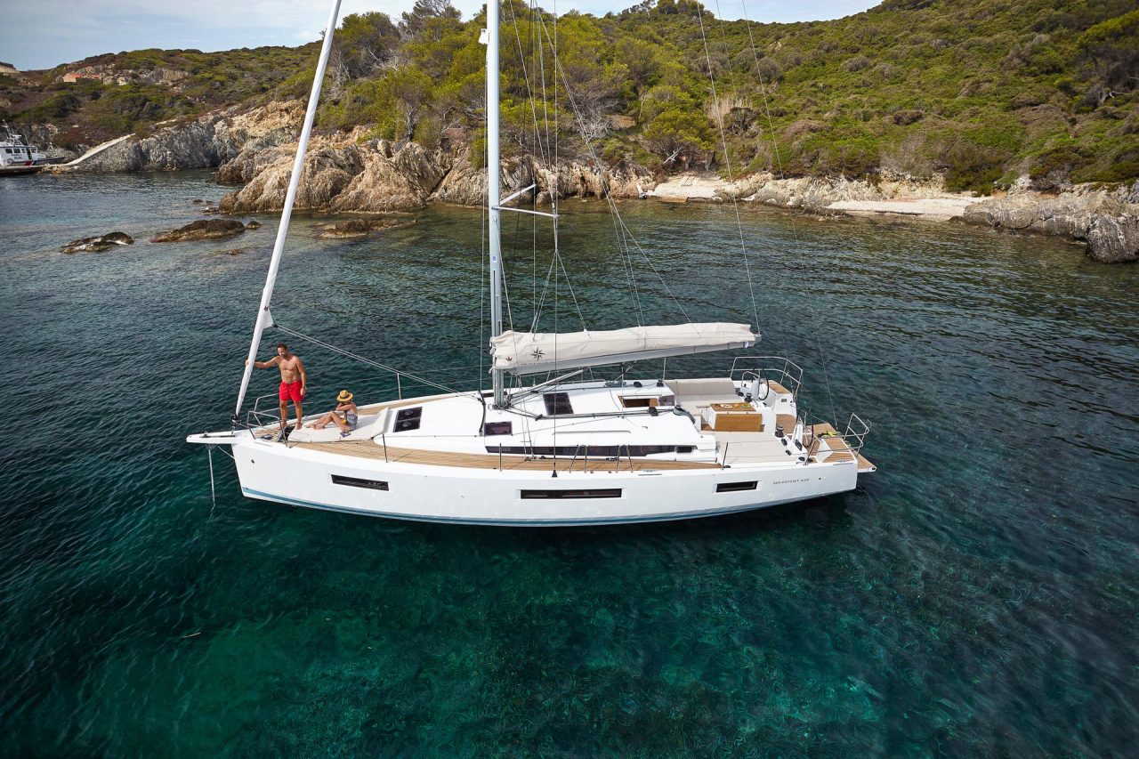 Aerial view of the Jeanneau Sun Odyssey 440 sailing monohull at anchor with a woman and a man enjoying foredeck