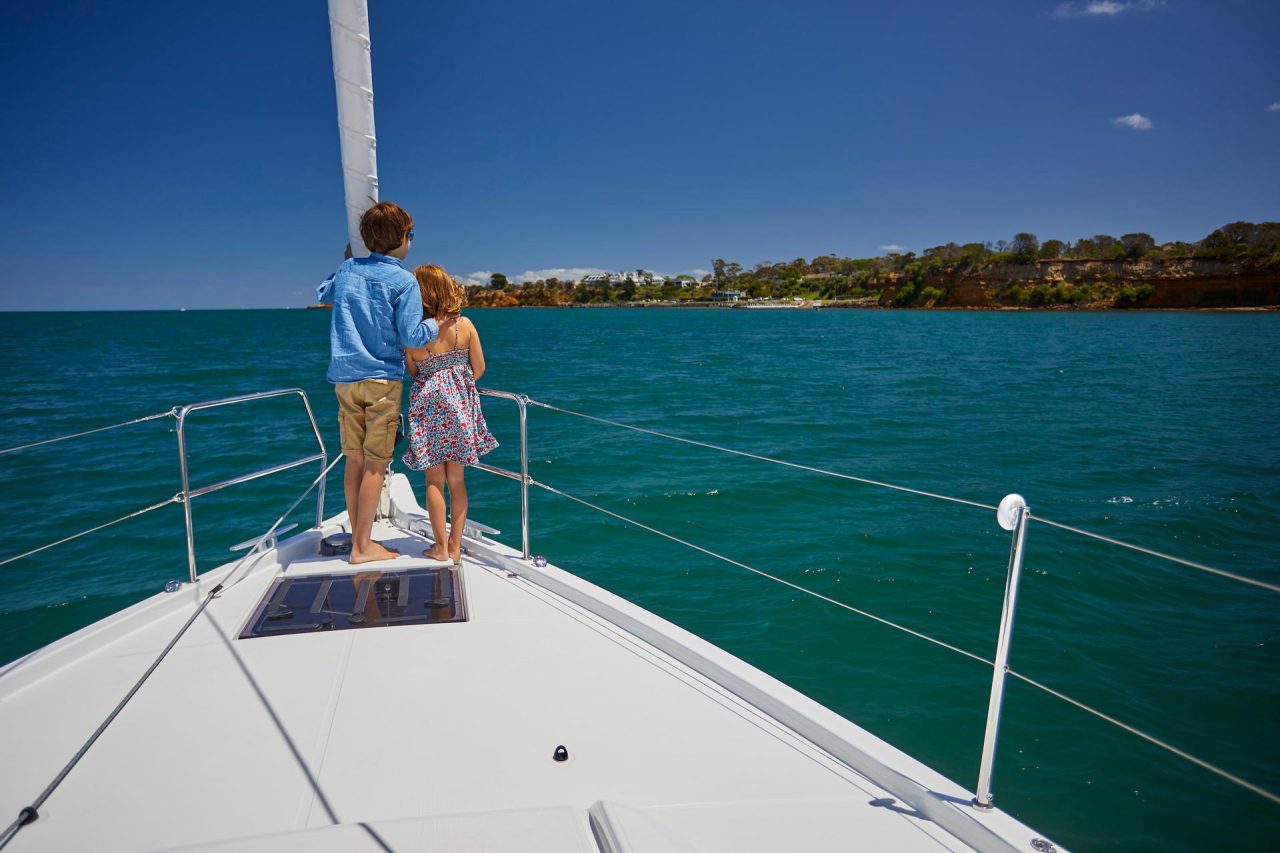 Children at the bow of the Jeanneau Sun Odyssey 490 sailing monohull