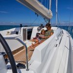 Mother reading a book with her daugther on the Jeanneau Sun Odyssey 490 cockpit